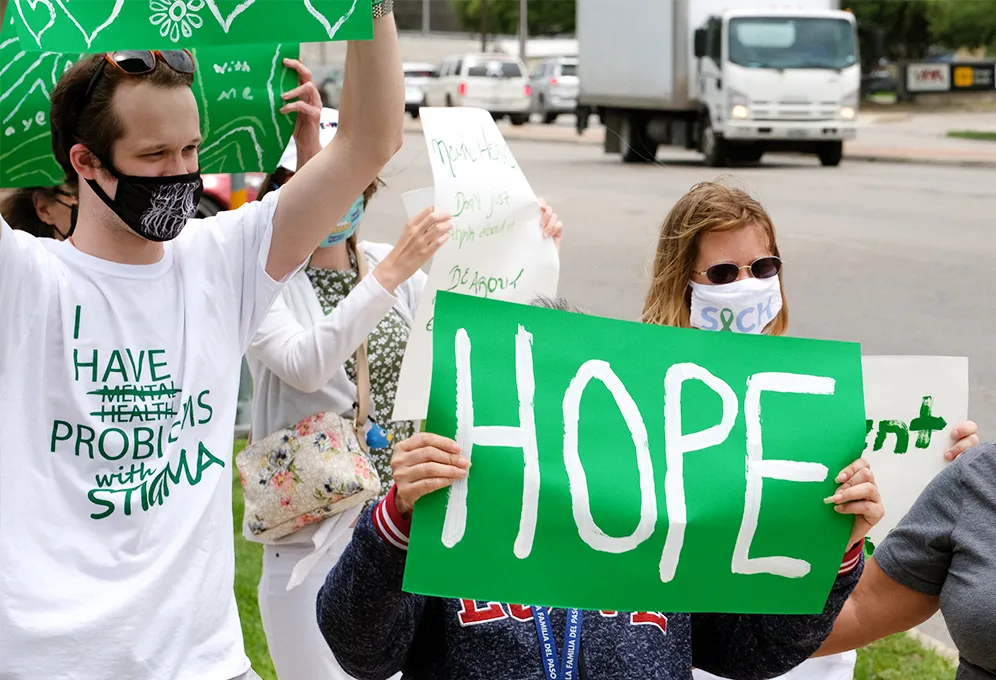 Miembros de Clubhouse al aire libre sosteniendo un letrero verde que dice HOPE (esperanza)